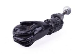 A 20th Century black painted metal door knocker in the form of a hand holding a ball.