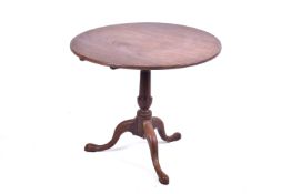 A Georgian mahogany tripod tilt top table. Raised on as turned column over tripod support.