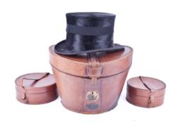 A vintage black top hat in fitted box and two collar boxes.