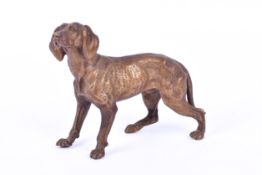 A gilt bronze figure of a hunting dog. Unmarked, head raised, 12cm long.