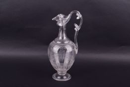 An engraved glass claret jug with repeating etched detail.