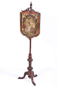 A 19th Century pole screen with floral collage embroidery behind glass (cracked).