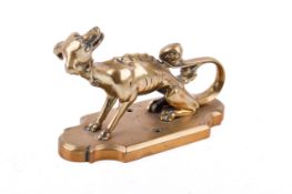 A Victorian Gothic Revival brass coat hook in the form of a mythical creature. Raised on a plinth.