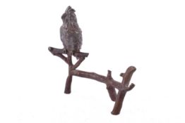 A continental patinated bronze figurine modelled as a parrot on a branch.
