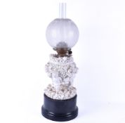 A Victorian table oil lamp with porcelain cherubs and floral details, unmarked.