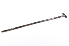A carved horn walking stick with inlaid decoration.