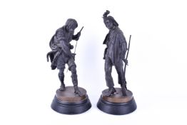 Two bronze finish spelter figures of a cowboy and a hunter with fur cape.
