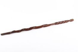 Carved wooden walking cane with snake decoration.