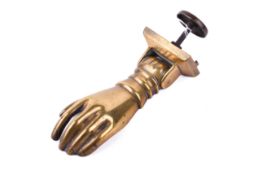 A 20th Century brass door knocker in the form of a hand on hinge. Complete with fitting.