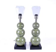 A pair of contemporary three ball green ceramic table lamps. Raised on a black wooden base.