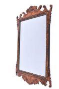 A walnut veneered fretwork framed wall mirror.