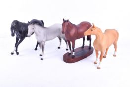Four assorted Beswick porcelain horses. Including 'Thoroughbred' raised on an oval wooden stand.