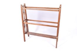 An oak bathroom towel rail. Having turned spindles and a lower shelf. H86cm x W76.