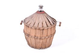 A large vintage French glass carboy bottle in basket.