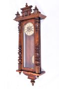 A Vienna style mahogany cased wall clock. Brass and plastic dial with Roman numerals.