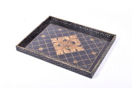 An ebonized wooden serving tray. Having gilt floral design, with pierced gallery.