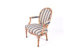 A Louis XVI style armchair with striped upholstery.