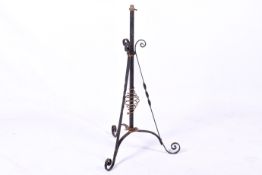 A black painted wrought iron standard lamp in Benson style with copper florets and scrolling