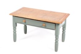 20th Century pine top coffee table. Having a drawer, raised on turned painted supports.