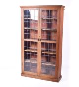 An Arts and Crafts style glass leaded glazed doors oak bookcase.
