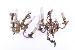 Pair of brass chandeliers with four curved candle style bulb holders.