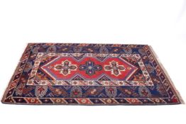 A vintage Turkish blue and red ground rug.