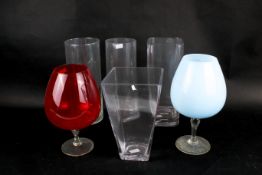 A group of six assorted glass flower vases. Various shapes and sizes.