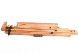 A compact wooden artist field tripod easel.