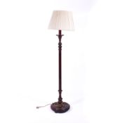 A 20th century carved wooden standard lamp. Raised on a circular base.