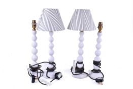 A group of four Pooky table lamps with bobbin turned style columns. Painted white, two with shades.