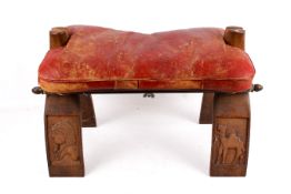 Middle Eastern carved camel saddle stool having leather pad seat.