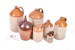 A collection of seven assorted stoneware flagons. Various sizes, some local interest.