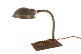 A circa 1930s gooseneck desk lamp with a cast metal rectangular base.