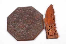 An Indian carved hardwood folding table. The octagonal top with grape and vine decoration.