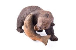 A Japanese Kibori Kuma carved wooden bear catching a salmon.