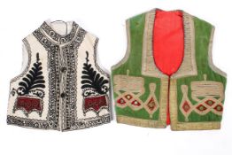 A vintage Afghan embroidered waistcoat and a cream and black example.