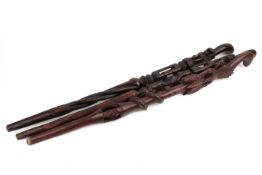 Three Tribal style walking sticks. Pierced and carved with animals and foliage, largest H46cm.
