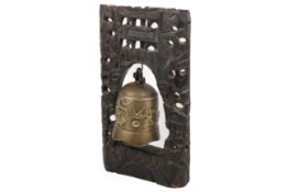 A Chinese Tibetan brass temple bell mounted in a carved hardwood frame.