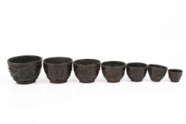 A Chinese 18th/19th century graduated set of seven carved coconut shell cups.