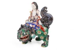 A Japanese polychrome model of a deity riding a shishi. Unmarked, H22cm.