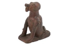 A dark earthenware model of a dog, possibly an Indonesian Batak oracle figure.