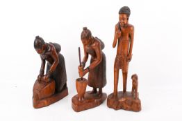 Three wooden carvings of figures at work.