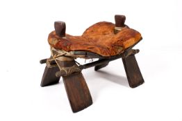 A large early 19th century Egyptian camel saddle-stool on rigid X frame base with bound stretchers.