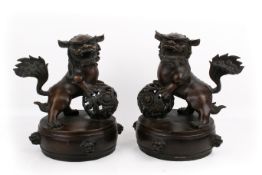 A pair of Chinese bronze dogs of fo on drums.