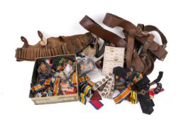 A group of military belts, medal ribbons, buttons and badges.