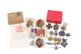 A small group of WWII medals, buttons and other badges.