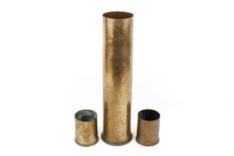 Three brass shell cases. Two 76mm ARMDC and dated 1977, height 11.