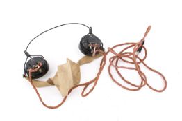 A pair of WWII period black signaler's headphones. Marked 'DLR No1 4.35A', with brown cord.