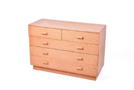 A mid-century oak chest of drawers. Having two short over three long, raised on a plinth base.