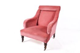 A Howard style pink upholstered armchair.